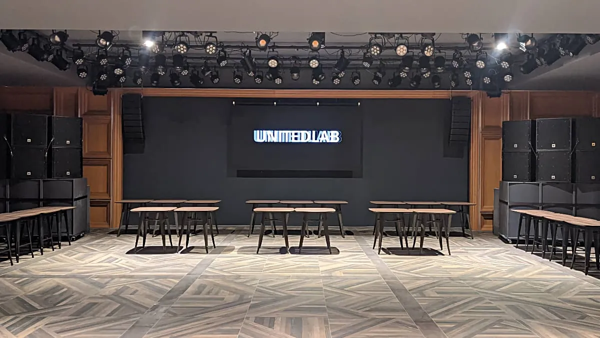 2F SPACE。テーブル席の正面に設置されたLEDビジョンに UNITEDLAB のロゴを表示している